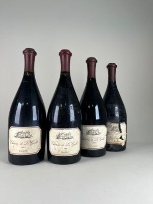 quatre bouteilles de vin sont alignées sur une table