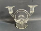 un bougeoir en verre transparent sur lequel sont posées deux bougies