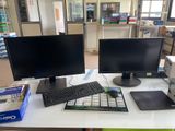 un bureau équipé de deux écrans et d'un clavier