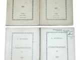 trois vieux livres sont posés les uns sur les autres sur une surface blanche
