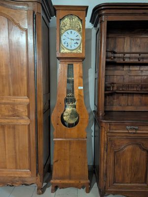 une horloge de parquet posée à côté d'un grand meuble en bois