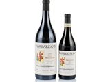 two bottles of red wine sitting next to each other on a white surface