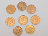 six types différents de pièces d'or sur une surface blanche