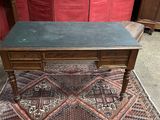 un petit bureau au plateau vert posé sur un tapis