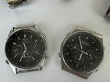 three watches are sitting next to each other on a white surface
