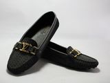 une paire de chaussures noires ornées de chaînes dorées