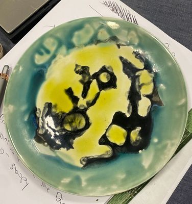 a plate with a smiley face painted on it sitting on a table