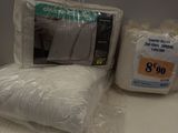 two pillows, a pillow, and a pillow case sitting on a table