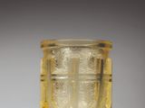 a yellow glass cup sitting on a white surface