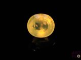 un gros plan d'une boule de cristal jaune posée sur une surface noire