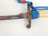 a knife with a blue rope attached to it on a white surface