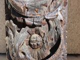 a wooden carving of a face on the side of a building