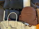 a lot of purses that are sitting on the floor