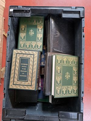 de nombreux livres dans une boîte noire posée par terre
