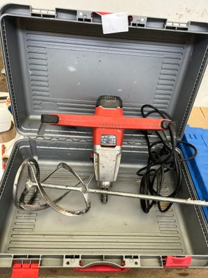 a red and black drill in a tool case