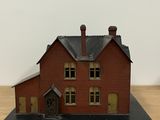 a small model of a red house on a table