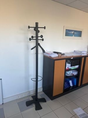 an image of a room with a desk and a coat rack