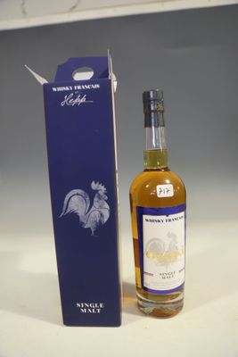 the bottle is next to the box on the table