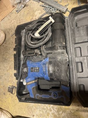 une image représentant une boîte à outils contenant une perceuse filaire et d'autres outils