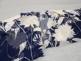 a blue and white floral print shirt laying on a bed