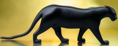 une figurine représentant un chat noir posée sur une table