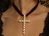 a woman that is wearing a necklace with a cross on it