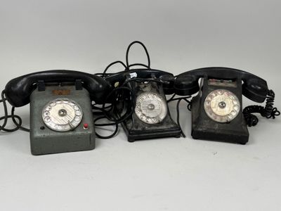 trois téléphones à l'ancienne sont alignés sur une surface blanche