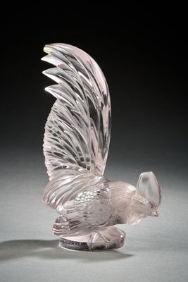 a clear glass sculpture of a bird on a black surface