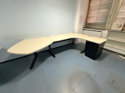 un bureau d'angle dans une pièce vide dotée d'une fenêtre