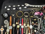 many different types of watches and bracelets laid out on a table
