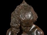 a bronze statue of a woman holding a cell phone