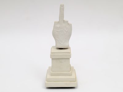 une statue représentant une main tenant un couteau, posée sur un socle