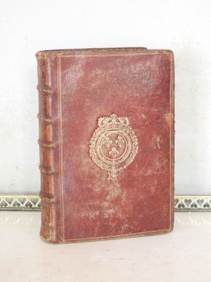 a brown book with a crest on it sitting on a table