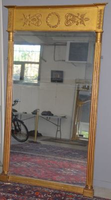 un grand miroir dans une pièce, avec un vélo en arrière-plan