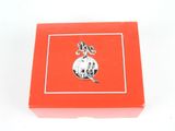 a small red box with a silver charm on it
