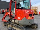 a close up of a red tractor parked in a parking lot