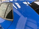 a close up of a blue car parked in a parking lot