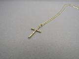 un collier avec une croix en or sur un fond gris