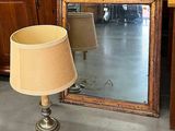 une lampe posée sur une table à côté d'un miroir