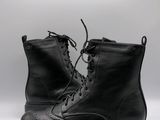black leather boots with laces and rubber soles on a white background