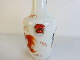un vase blanc orné d'un motif rouge et noir