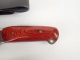 a knife that is laying on a table next to a wallet