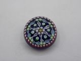 a picture of a glass button with a flower design on it
