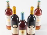 several bottles of wine are lined up in a row on a white surface