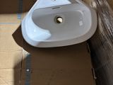 a white sink sitting on top of a cardboard box in a room