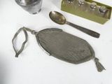 a small mesh bag with a spoon and spoon rest next to it