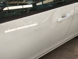 a white car parked in a garage with its door open