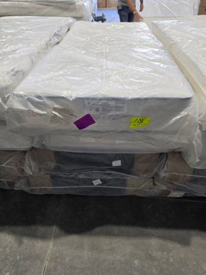 many mattresses on the floor in a warehouse
