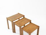 trois tables en bois empilées les unes sur les autres sur une surface blanche