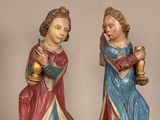 deux figurines représentant deux femmes tenant des verres à vin posés sur une table